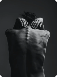 Homem com anorexia, sem camiseta, em uma sala escura